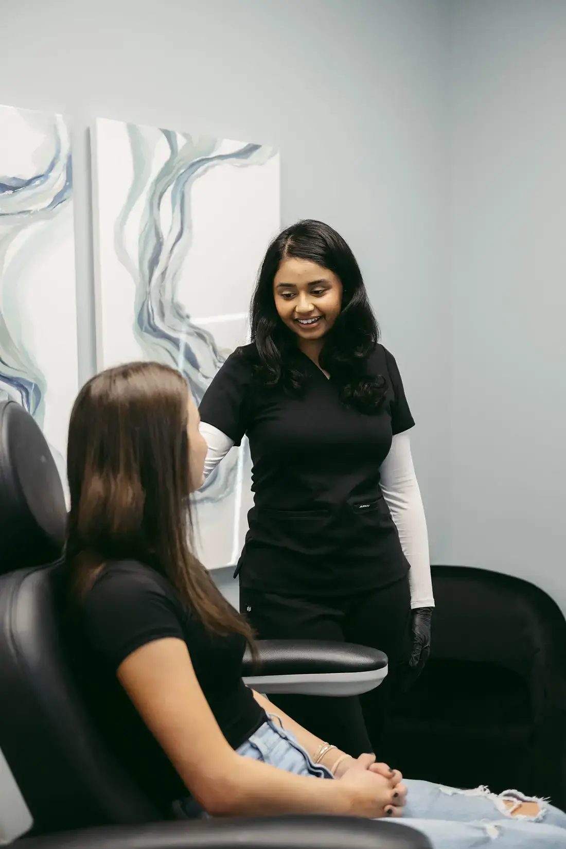 An aesthetician consulting with a client in a treatment room at 7 Seas Medical Spa in Augusta, GA